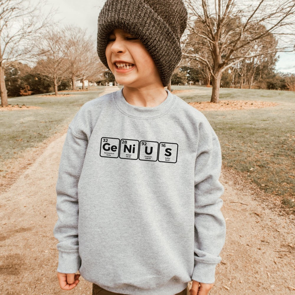 a young boy wearing a grey genius sweatshirt and a beanie