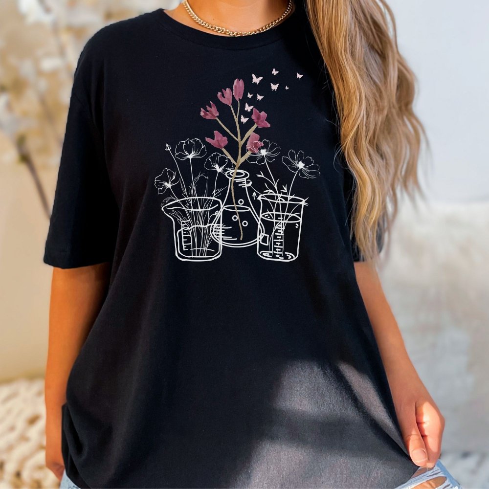 Black t-shirt featuring a unique floral design with flowers in laboratory beakers and flasks, perfect for lab technicians who love a mix of science and nature. This casual tee combines a minimalist science theme with a stylish, comfortable fit.