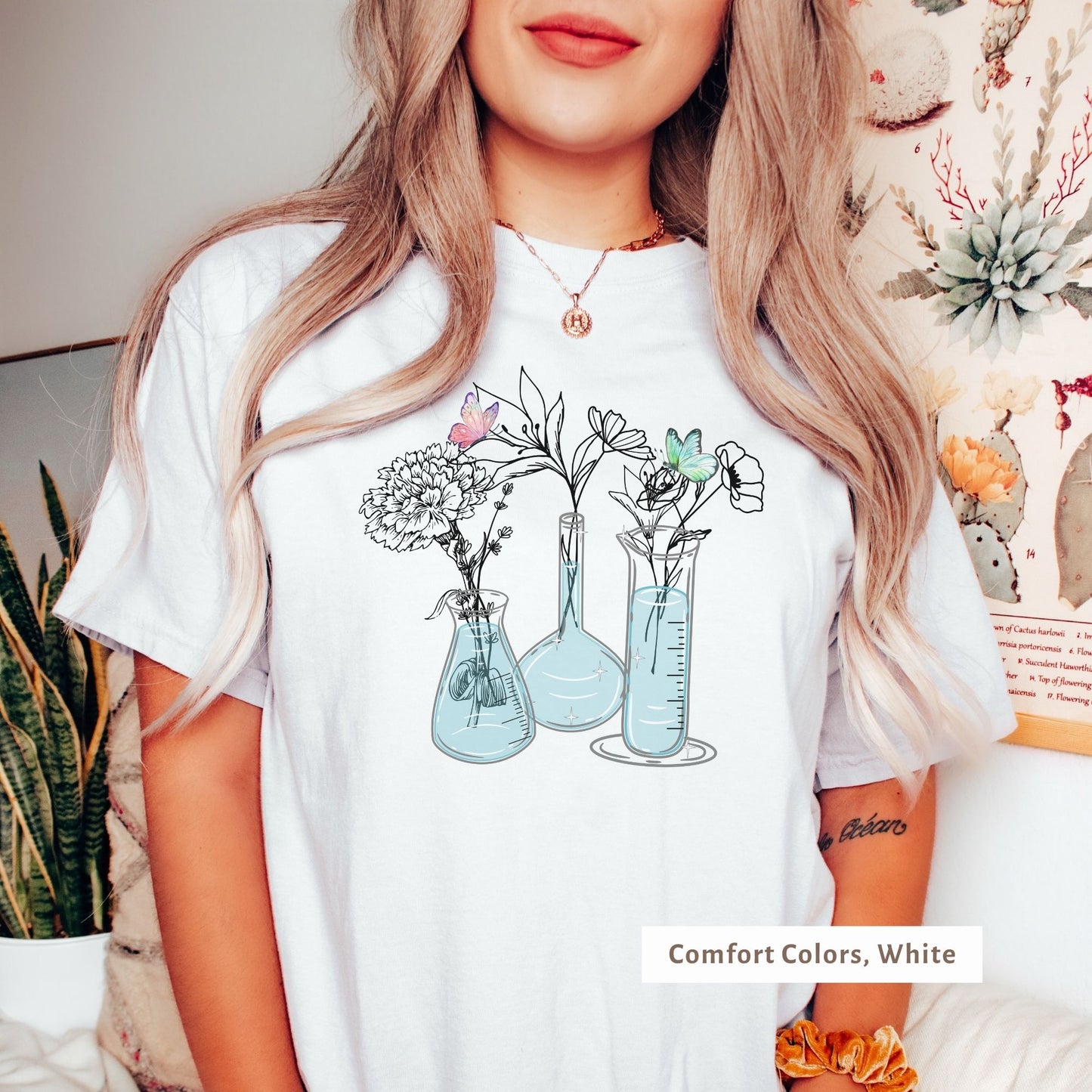 Brighten up your day with this white Comfort Colors tee! Featuring a playful mix of beakers, flasks, flowers, and butterflies, it’s a fresh and fun way to show off your love for science and nature in a comfy, casual style.