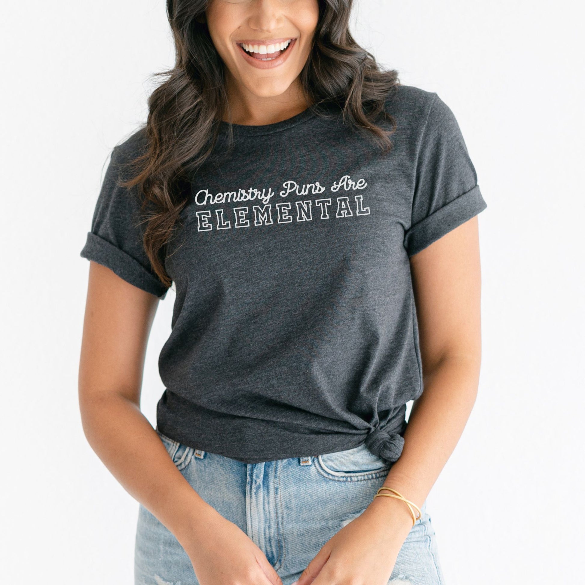 a smiling woman in a gray shirt and jeans