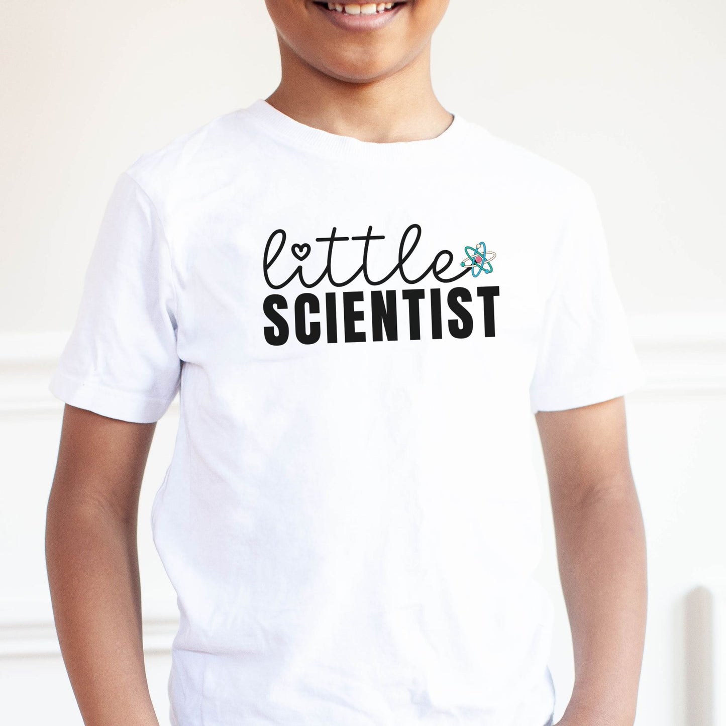 a young boy wearing a little scientist t - shirt