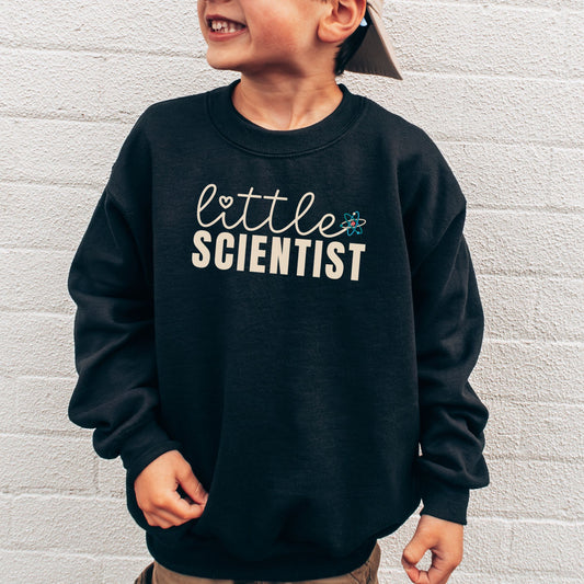 a young boy wearing a black sweatshirt with the words little scientist printed on it